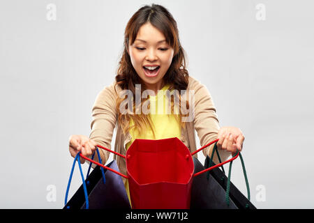 Felice donna asiatica con open borse per lo shopping Foto Stock