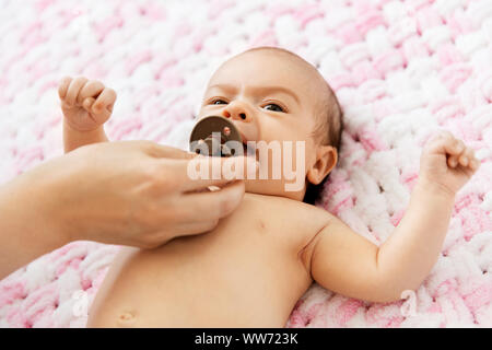 Madre la mano dando il succhietto per la nostra bambina Foto Stock