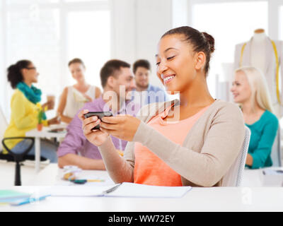 Designer di moda con smartphon oltre studio Foto Stock