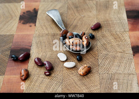 Fagioli fagioli misti, legumi, tavola di legno, cucchiaio Foto Stock