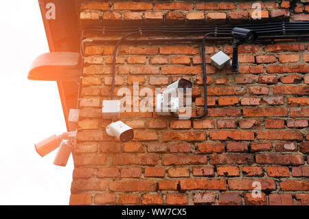 Circuito chiuso telecamera multi-angolo sistema TVCC. una fila di telecamere appeso su un vecchio muro di mattoni. sicurezza Foto Stock