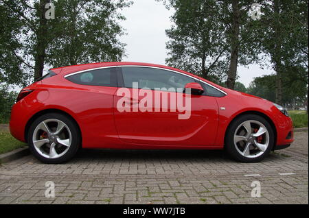 Almere, Paesi Bassi - 29 Maggio 2016: Rosso Opel Astra GTC parcheggiato in un parcheggio pubblico Foto Stock