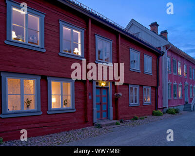 La Svezia, Smaland, EksjÃ¶, colorate case di legno nella città vecchia di illuminazione serale Foto Stock