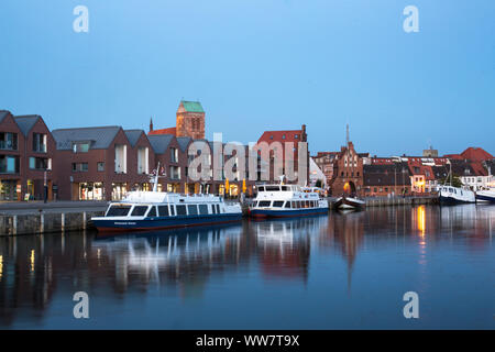 Germania, Wismar, edifici commerciali e imbarcazioni turistiche nel vecchio porto Foto Stock