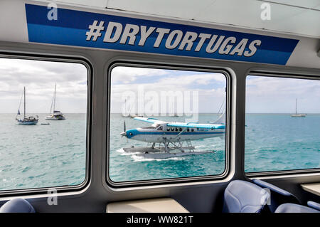 Vista di idrovolante attraverso la finestra del traghetto con #DryTortugas hashtag. Entrambi barca + trasporto in aeroplano turisti al Parco Nazionale di Dry Tortugas da Key West. Foto Stock