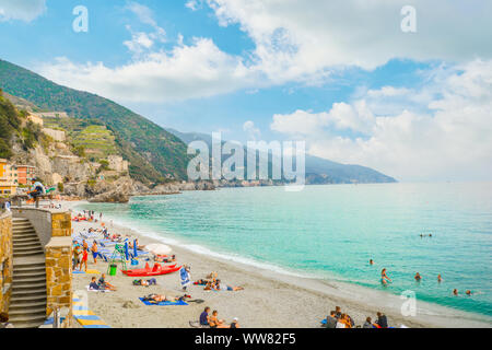 Il mare e la spiaggia sabbiosa spiaggia di Fegina al Cinque Terre Italia resort borgo di Monterosso al Mare con turisti che si godono la Riviera Italiana Foto Stock