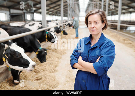 Giovane lavoratore di sesso femminile che di contemporaneo dairy farm Foto Stock