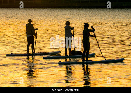 Southport, Merseyside, 13 settembre 2019. Regno Unito: Meteo Boarders paddle, Stand Up Paddle Boarding, paddleboarding, paddle boarders navigare off nel tramonto come la sera tardi il sole accarezza la superficie del lago marino a Southport, Merseyside. Credito: Cernan Elias/Alamy Live News Foto Stock