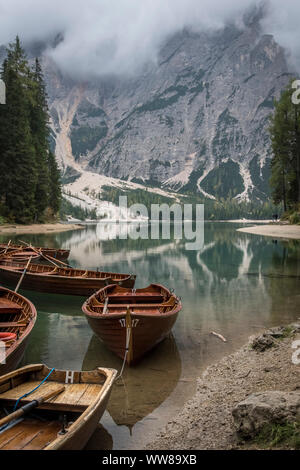 Escursione autunnale intorno al Lago di Braies nelle Dolomiti, Italia. Imbarcazioni a remi in legno che giace sulla riva Foto Stock