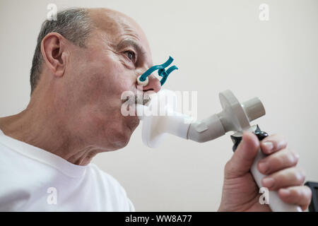 Senior ispanico uomo uomo test funzione di respirazione da spirometria. Diagnosi della funzione respiratoria in malattia polmonare Foto Stock