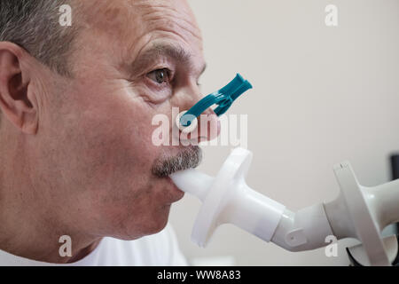 Senior ispanico uomo uomo test funzione di respirazione da spirometria. Diagnosi della funzione respiratoria in malattia polmonare Foto Stock