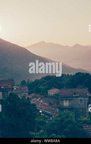 Alba sul Lopigna, piccolo borgo situato nel verde delle montagne della Corsica con tipiche case Foto Stock