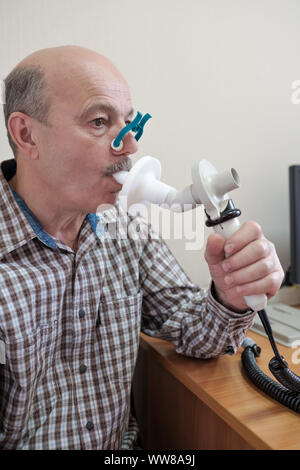 Senior ispanico uomo uomo test funzione di respirazione da spirometria. Diagnosi della funzione respiratoria in malattia polmonare Foto Stock