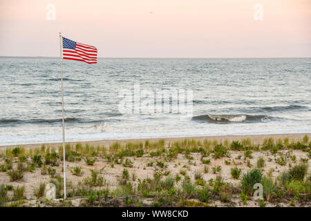 Noi bandiera sorvolano Dewey Beach al tramonto Foto Stock
