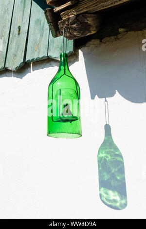 Pernersdorf, bottiglia di vino con bicchiere di vino all'interno sul lato anteriore di un Presshaus (premere casa) in Kellergasse (cantina lane) in Pfaffendorf nel Weinviertel (vino trimestre), Austria Inferiore, Austria Foto Stock