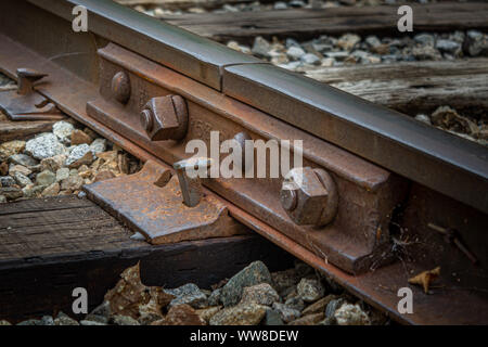 Primo piano di Rusty, vecchia ferrovia spike e i dadi su abbandonato i binari della ferrovia in New Hampshire Foto Stock