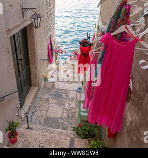 Scorcio verso il mare lungo le strade della città di Rovigno, un negozio di abbigliamento per donna, Rovigno, Istria, Croazia Foto Stock