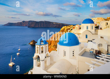 La cittadina di Oia sull isola di Santorini, Grecia con edifici tradizionali con le cupole blu Foto Stock