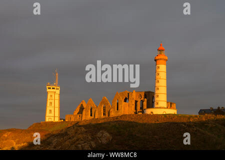 Faro al mattino, Saint Mathieu faro con la rovina di abbazia benedettina, Pointe Saint-Mathieu, Plougonvelin, Finisterre, Bretagna Francia Foto Stock