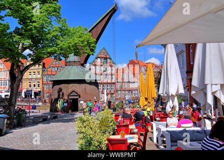 Street cafe al mercato del pesce con pedale in legno gru e semi-case con travi di legno nella città vecchia, la città anseatica di Stade, inferiore Elbe, Altes Land Bassa Sassonia, Germania settentrionale, Germania Foto Stock