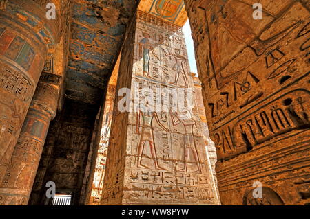 Sala Colonne con rilievi e colori originali nel secondo cortile nella morte tempio di Ramses III Medinet Habu in Thebes-West, Luxor, Alto Egitto Egitto Foto Stock