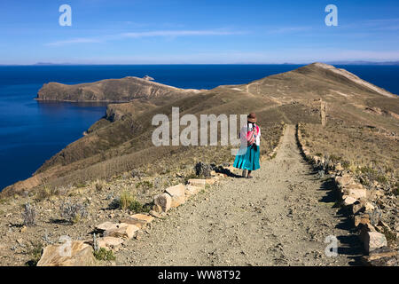 ISLA DEL SOL, il lago Titicaca, BOLIVIA - 7 Novembre 2014: donna non identificato in usura tradizionale camminando sul percorso su Isla del Sol in Bolivia Foto Stock