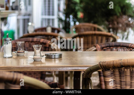 A sparare da un cafe vi è un tè tradizionale di vetri e di un tavolo di legno. foto ha preso da izmir/Turchia. Foto Stock