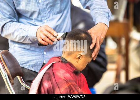 Barbiere di strada in Bac Ha mercato nella città rurale di Lao Cai vicino a Sapa Vietnam Asia Foto Stock