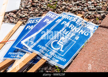 La segnaletica a terra per il 4 luglio il giorno di indipendenza disabili parcheggi con simbolo blu e firmare per il parcheggio riservato è richiesto il permesso di trainare la zona Foto Stock