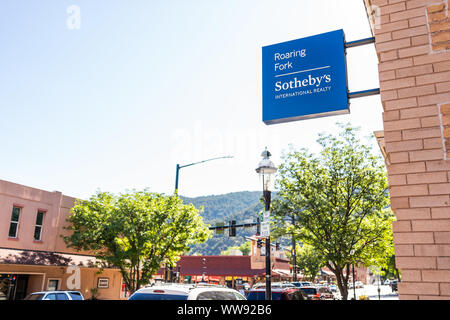 Glenwood Springs, Stati Uniti d'America - 10 Luglio 2019: il centro storico di estate street in Colorado con architettura in mattoni e firmare per la Roaring Fork Sotheby's giornat Foto Stock