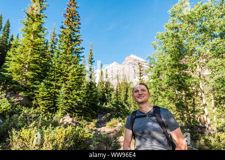 Maroon Bells vista picco in Aspen Colorado con felice turistica zaino uomo escursionista cercando nel luglio 2019 estate sul percorso trail strada un ampio angolo di visione Foto Stock