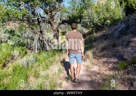 Retro dell uomo a camminare sulle voci nel deserto Sentiero Natura e Split campeggio di montagna in estate in Dinosaur National Monument Park, Utah Foto Stock