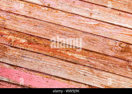 Il vecchio ruvido di tavole di legno con crepe come sfondo. Doghe in legno texture con la meschina vernice rossa Foto Stock
