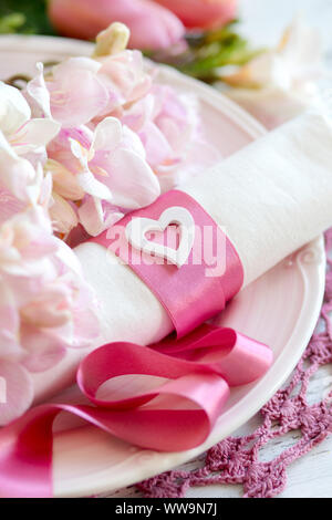 Nozze di festa messa in tavola con fiori di colore rosa e il nastro di inchiostro Foto Stock