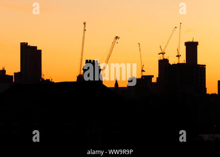 Silhouette di Leeds skyline durante il sunrise. Yorkshire il nuovissimo edificio più alto "Altus House' è in costruzione tra gli altri edifici di nuova costruzione. Foto Stock