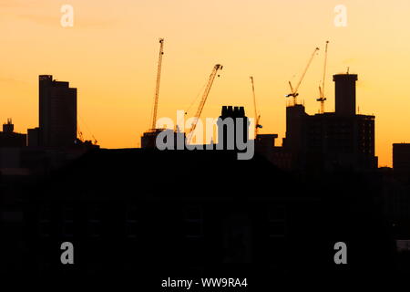 Silhouette di Leeds skyline durante il sunrise. Yorkshire il nuovissimo edificio più alto "Altus House' è in costruzione tra gli altri edifici di nuova costruzione. Foto Stock