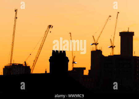 Silhouette di Leeds skyline durante il sunrise. Yorkshire il nuovissimo edificio più alto "Altus House' è in costruzione tra gli altri edifici di nuova costruzione. Foto Stock