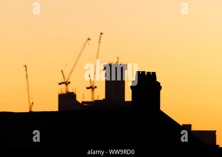 Silhouette di Leeds skyline durante il sunrise. Yorkshire il nuovissimo edificio più alto "Altus House' è in costruzione tra gli altri edifici di nuova costruzione. Foto Stock