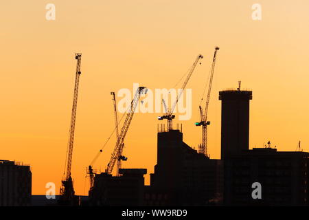 Silhouette di Leeds skyline durante il sunrise. Yorkshire il nuovissimo edificio più alto "Altus House' è in costruzione tra gli altri edifici di nuova costruzione. Foto Stock