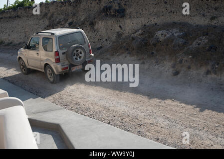 Santorini, Grecia - 23 Giugno 2018: una piccola unità SUV lungo una strada sterrata a Santorini a metà estate. Foto Stock