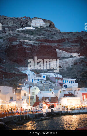 Santorini, Grecia - 24 Giugno 2018: Cena folla pack gli illuminati ristoranti sulle rive della Baia di Ammoudi in Oia, una popolare destinazione turistica sul Foto Stock