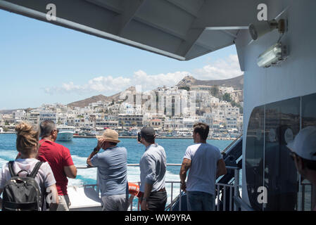 Naxos, Grecia - 28 Giugno 2018: La città di Naxos in lontananza come un traghetto tira fuori del porto di Naxos. Foto Stock