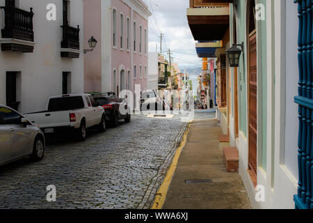 Strada di ciottoli della Vecchia San Juan tra le case di architettura coloniale scende al mare Foto Stock