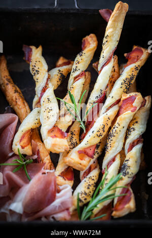 Pane appena sfornato in casa della pasta sfoglia i grissini con affumicato Prosciutto cotto e semi di papavero Foto Stock