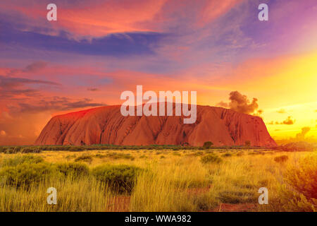 Le nuvole colorate in Cielo di tramonto su Ayers Rock in Uluru-Kata Tjuta National Park - a vivere il paesaggio culturale, Australia, Territorio del Nord Foto Stock