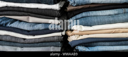 Ordinatamente ripiegati jeans denim nella carità shop. Foto Stock