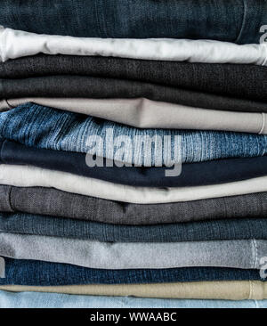 Ordinatamente ripiegati jeans denim nella carità shop. Foto Stock