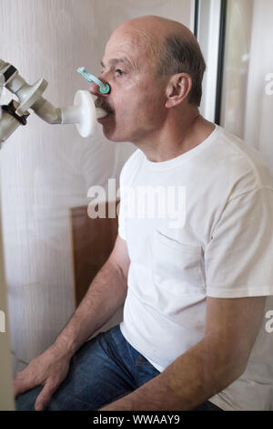 Senior ispanico uomo uomo test funzione di respirazione da spirometria. Diagnosi della funzione respiratoria in malattia polmonare. Orientamento verticale. Foto Stock