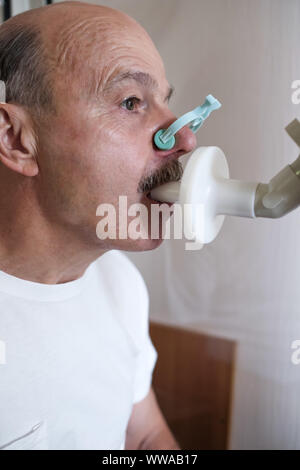 Senior ispanico uomo uomo test funzione di respirazione da spirometria. Diagnosi della funzione respiratoria in malattia polmonare. Orientamento verticale. Foto Stock