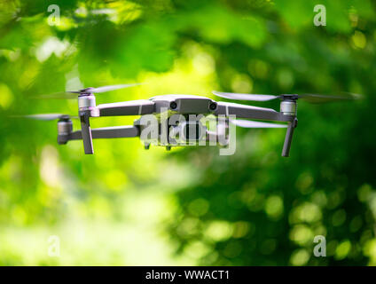 Flying drone con fotocamera passando all'interno di un forrest, sfondo naturale Foto Stock